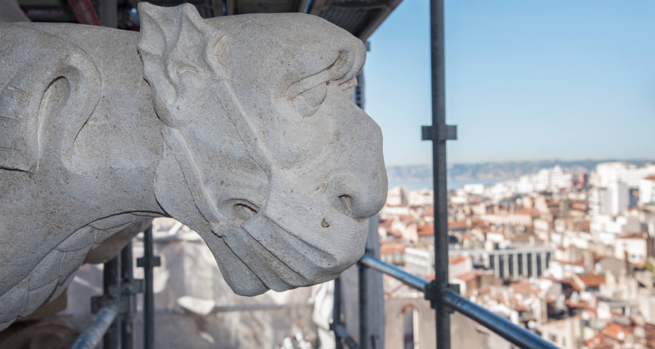 Sculpture en rénovation sur un site de construction à Marseille, symbolisant l'engagement de Groupe NEO dans des projets innovants et durables. Experts en construction, ferroviaire, immobilier et énergie, ils apportent leur savoir-faire local et international à des projets majeurs tout en respectant leur engagement environnemental.