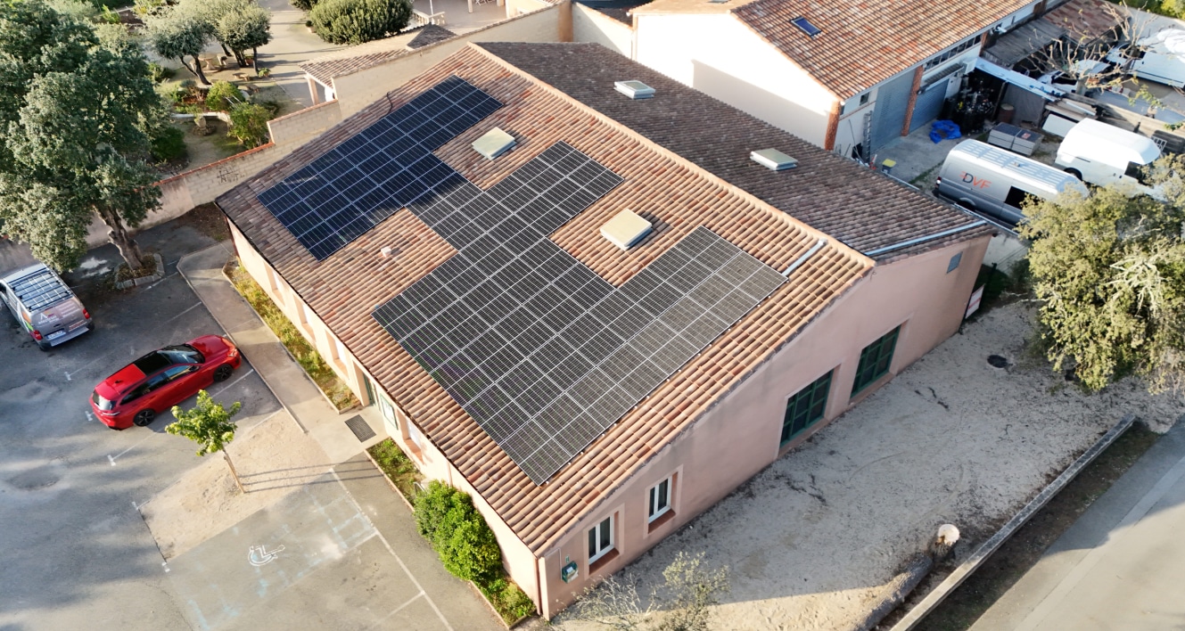 Toit d'un bâtiment avec panneaux solaires, illustrant l'engagement de Groupe NEO envers des solutions énergétiques durables. Cette entreprise familiale, experte en construction, ferroviaire et immobilier, se distingue par son professionnalisme et sa technologie avancée, contribuant à des projets majeurs en PACA et en Suisse, tout en mettant en avant son expertise locale et son engagement environnemental.